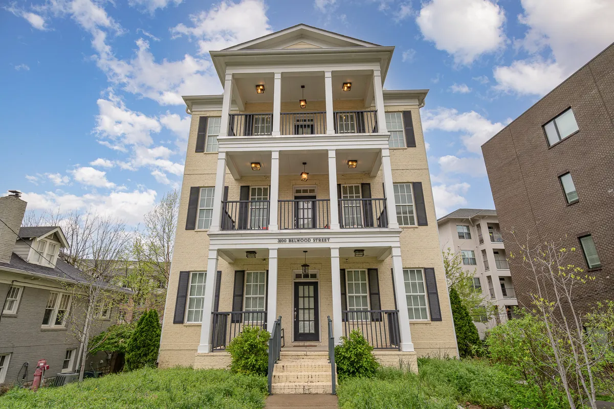 This image showcases the home's front porch with symmetrical architecture and welcoming columns, surrounded by neat landscaping. The image emphasizes the private entry and residential feel, setting the scene for a peaceful arrival experience.